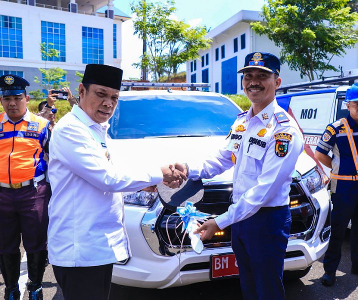 Pj Wali Kota Pekanbaru Muflihun menyerahkan kunci mobil patroli secara simbolis kepada Kepala Dishub Yuliarso di lapangan parkir Gedung Lipat Kajang, Kompleks Perkantoran Tenayan Raya, Rabu (13/3/2024). Foto: Istimewa.