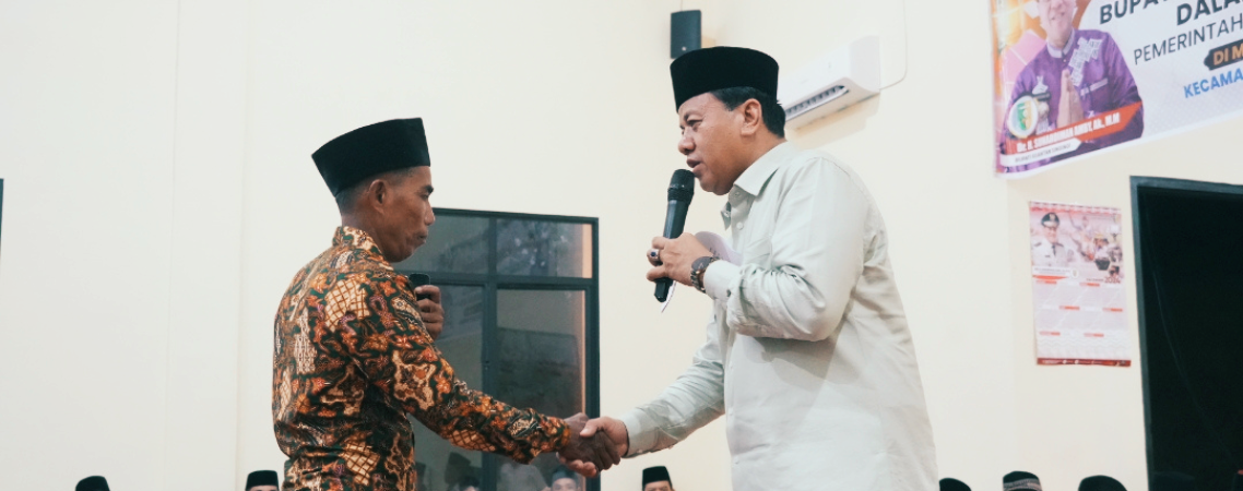 Bupati Kuansing, Suhardiman Amby menyampaikan selamat pada bilal Masjid Desa Muara Tiu Makmur yang mendapat hadiah umrah