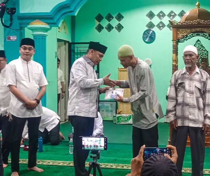 Pj Wali Kota Pekanbaru Muflihun menyerahkan uang bantuan ke pengurus Masjid Asy Syakuur, Rumbai Timur, Kamis (4/4/2024). Foto: Istimewa.