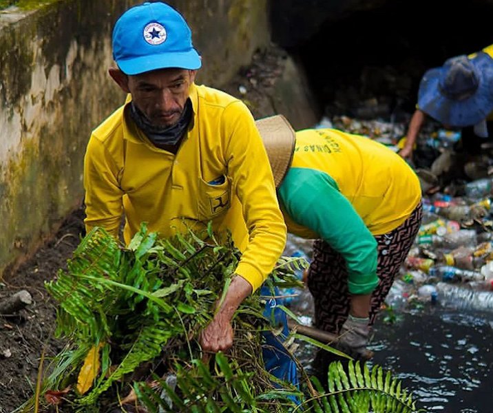Pasukan kuning Dinas PUPR Pekanbaru saat membersihkan drainase dari rerumputan dan sampah plastik di drainase Jalan Cut Nyak Dien. Foto: Istimewa.