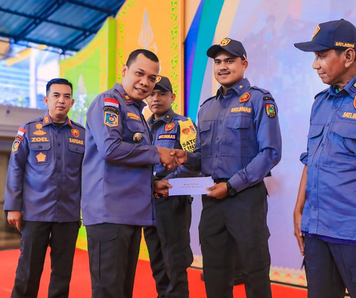 Pj Wali Kota Pekanbaru Muflihun menyerahkan honor petugas Satlinmas, Kamis (9/5/2024). Foto: Istimewa.