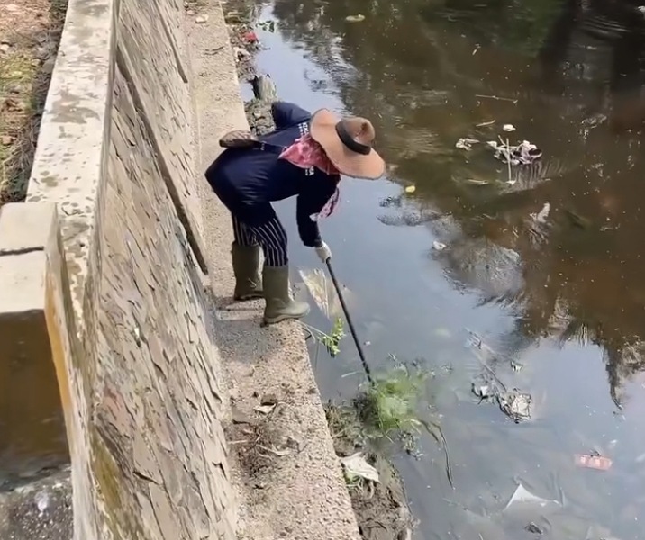 Pekerja Dinas PUPR Pekanbaru membersihkan sampah di aliran sungai Batak. Foto: Istimewa.