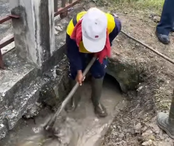 Pasukan kuning Dinas PUPR Pekanbaru membersihkan drainase Jalan Kuau. Foto: Istimewa.