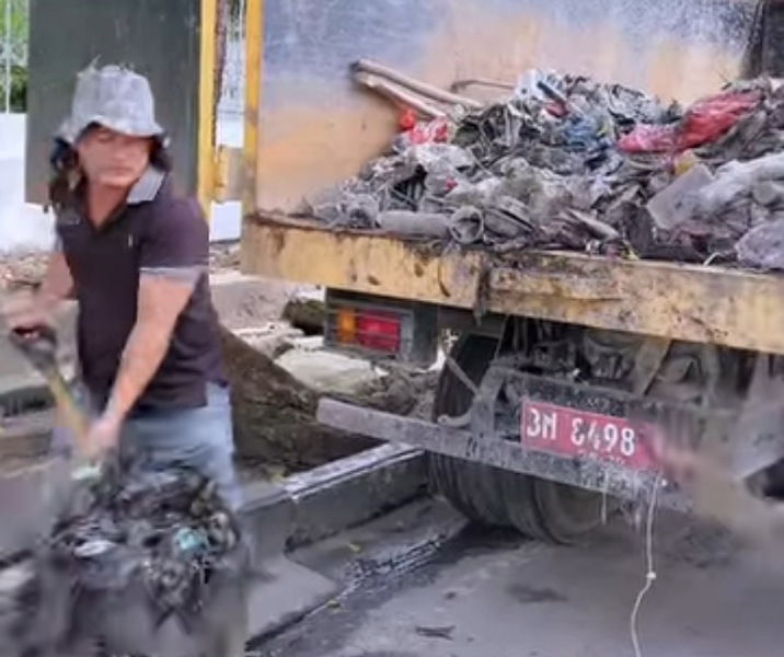 Pekerja Dinas PUPR Pekanbaru saat memindahkan tumpukan sampah ke dalam bak truk. Foto: Istimewa.