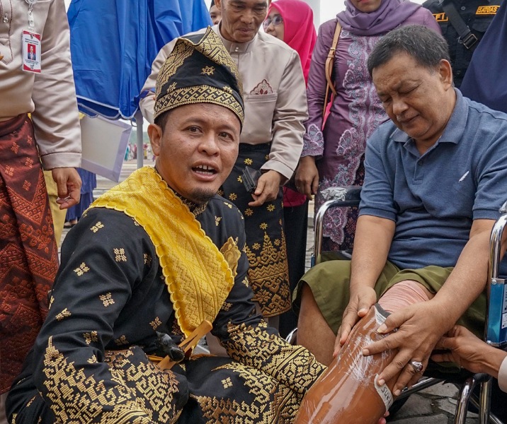 Wali Kota Pekanbaru Agung Nugroho saat memasangkan kaki palsu kepada penyandang disabilitas. Foto: Istimewa.