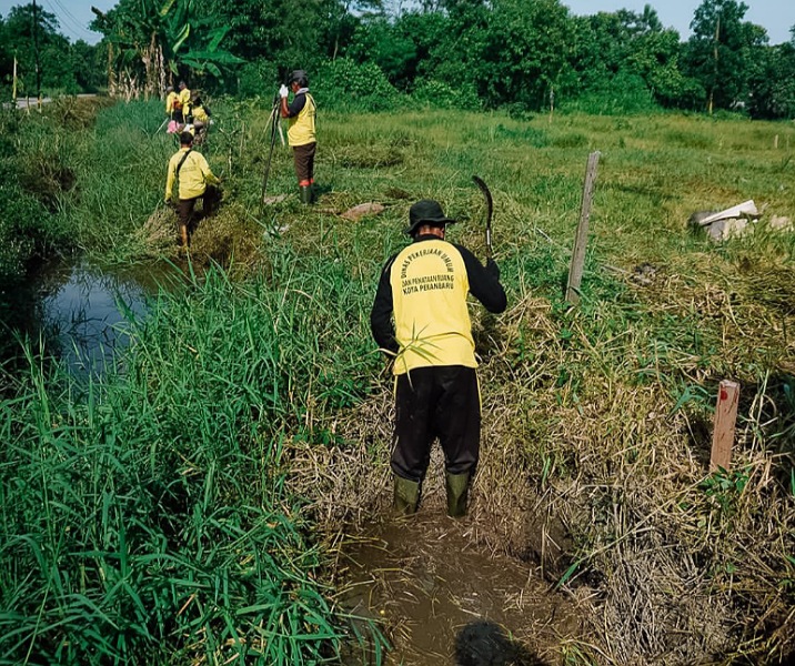 Pasukan kuning Dinas PUPR Pekanbaru membersihkan drainase di Jalan Punai, Bukitraya. Foto: Istimewa.