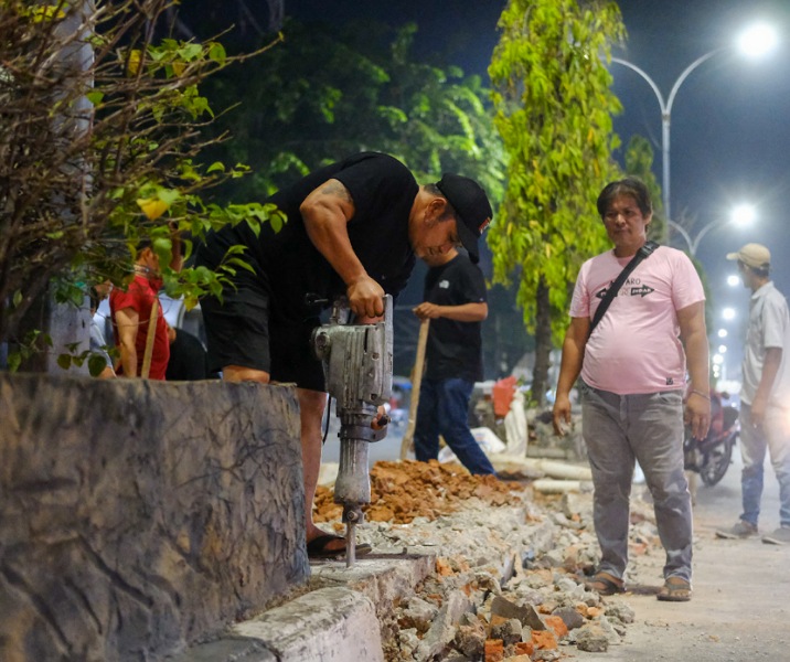 Pekerja sedang membongkar pembatas jalan yang akan difungsikan kembali sebagai U-turn di depan Pasar Cik Puan Pekanbaru. Foto: Istimewa.