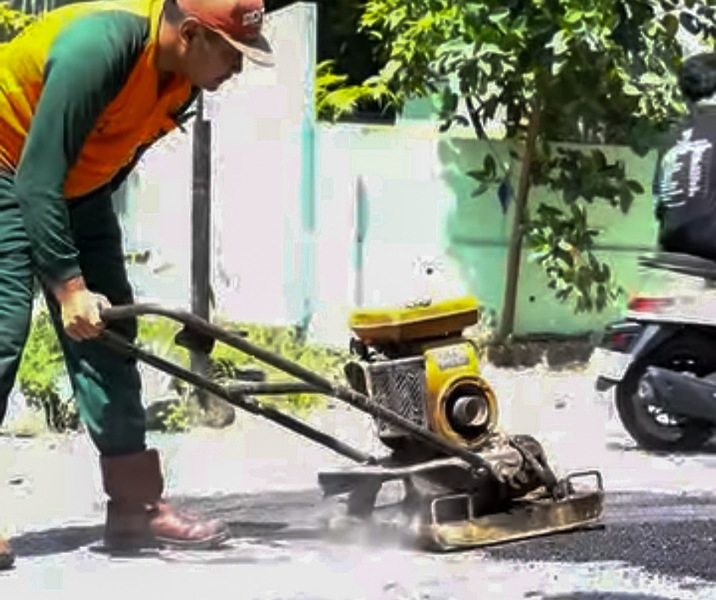 Pekerja Dinas PUPR Pekanbaru saat menambal lubang di Jalan Gunung Sahilan. Foto: Istimewa.