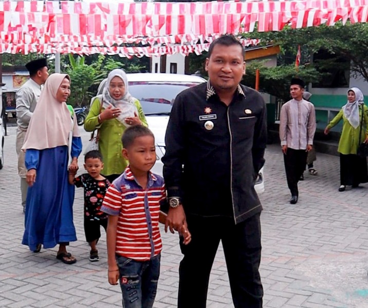 Camat Kulim Fajri Adha mengantarkan anak putus sekolah ke SD Negeri 133. Foto: Istinewa.