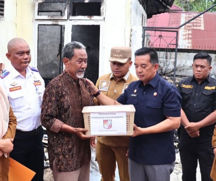 Kepala Dinsos Pekanbaru Zulfahmi Adrian menyalurkan bantuan kepada korban kebakaran. Foto: Istimewa.