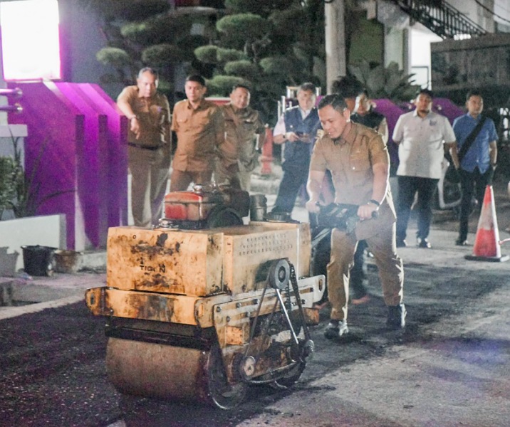 Wali Kota Pekanbaru Agung Nugroho saat ikut mencoba alat pemadat aspal saat proses tambal sulam lubang di Jalan Puyuh Mas, di samping RS Syafira. Foto: Istimewa.