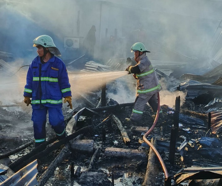 Petugas damkar melakukan proses pendinginan kios yang terbakar di Jalan SM Amin, Kamis (13/11/2025). Foto: Istimewa.