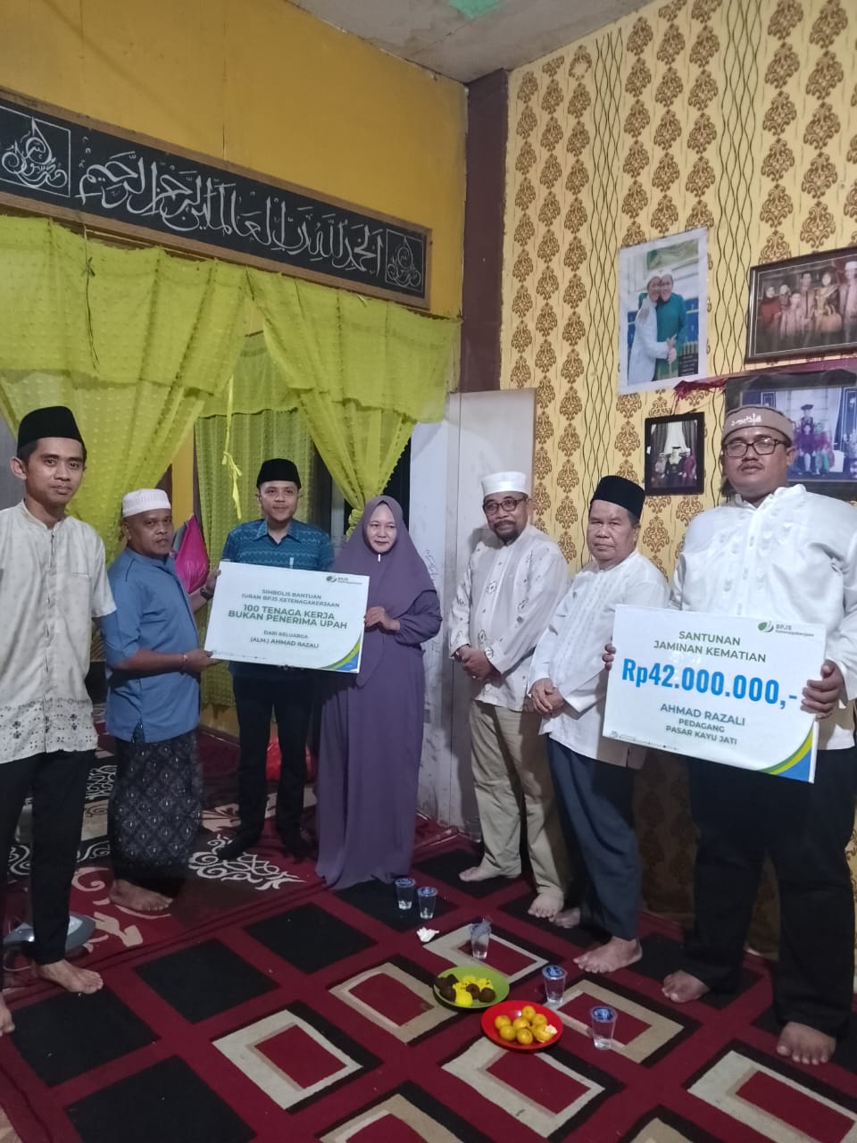 Ahli waris almarhum Ahmad Razali menyerahkan bukti pendaftaran 100 pekerja secara simbolis