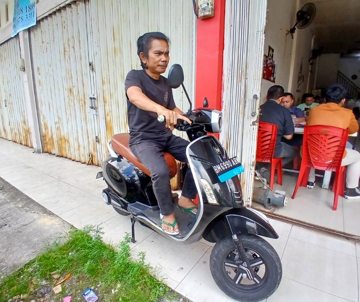 Saparuddin Siregar dengan skuter listriknya. Foto: Surya/Riau1.