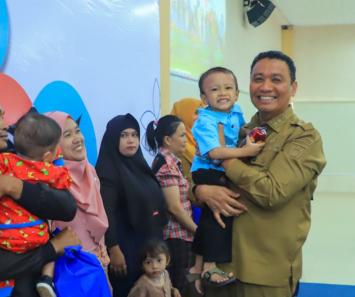 Wawako Pekanbaru Markarius Anwar menggendong balita yang akan diberi bantuan asupan gizi. Foto: Istimewa.