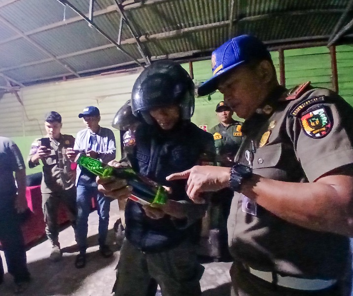 Petugas Satpol PP Pekanbaru saat mengecek kadar alkohol pada minuman bir Bintang di Nauli Cafe, Jumat (28/2/2026). Foto: Surya/Riau1.