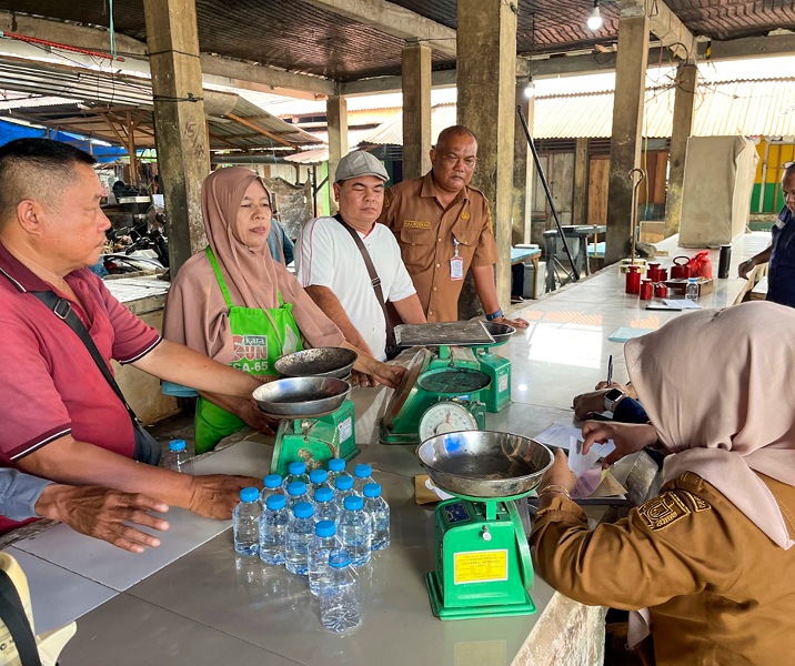 Petugas UPT Tera Ulang Disperindag Pekanbaru saat memeriksa timbangan salah seorang pedagang Pasar Limapuluh. Foto: Istimewa.