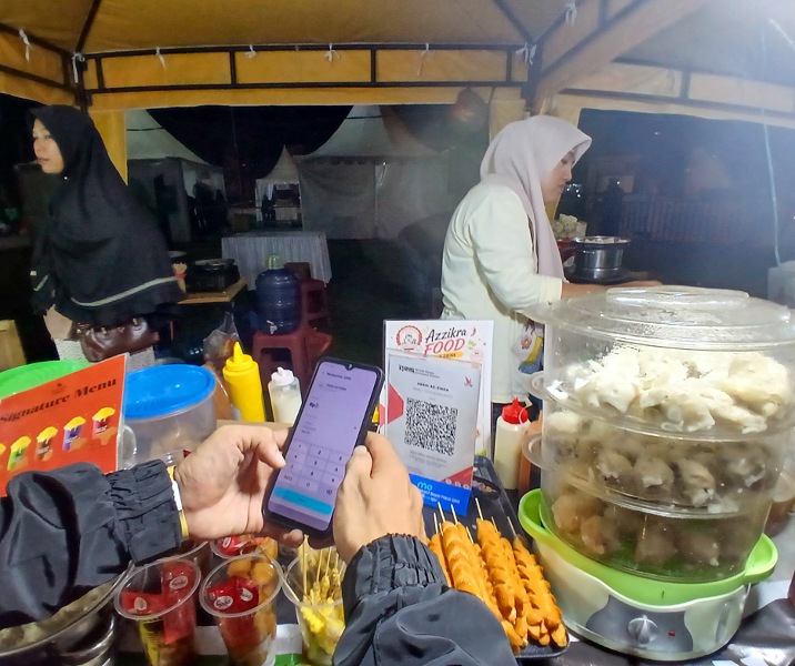 Seorang pembeli melakukan pembayaran bakso Gerai Az Zikra melalui QRIS di area Gelanggang Remaja Pekanbaru. Foto: Surya/Riau1.