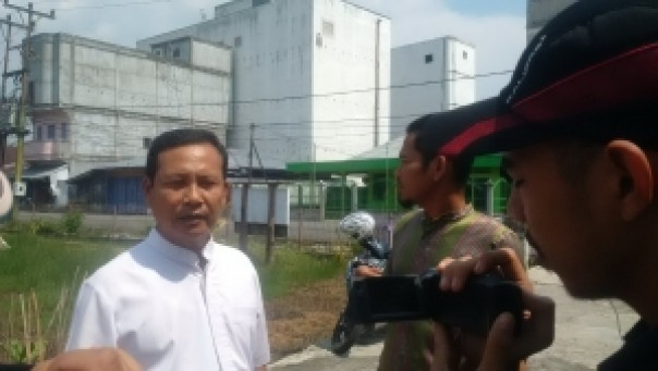 Poniman dan Berty Asmara dengan latar belakang ruko sarang burung walet di Selatpanjang. 