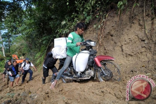 Tim Relawan bersusah payah membawa bantuan karena terhalang longsor di Kecamatan Lindu, Kabupaten Sigi. 