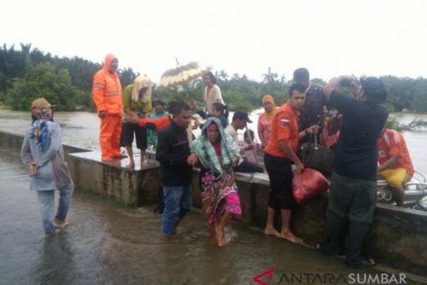 Petugas mengevakuasi korban banjir di Sasak Ranah Pasisia Pasaman Barat, Jumat.