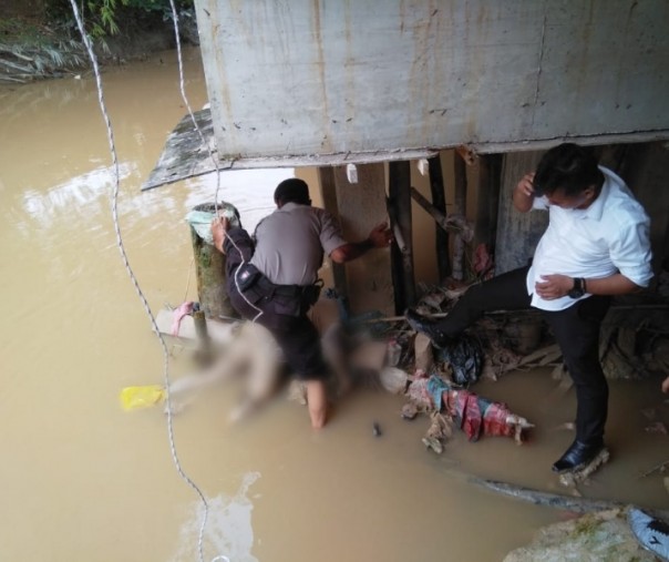 Polisi saat mengevakuasi jasad yang ditemukan tersangkut di bawah jembatan sungai Sail.