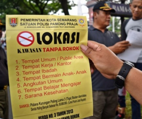 Petugas Satpol PP Kota Semarang memberikan surat peringatan kepada warga yang merokok di tempat umum. Foto: Antara. 