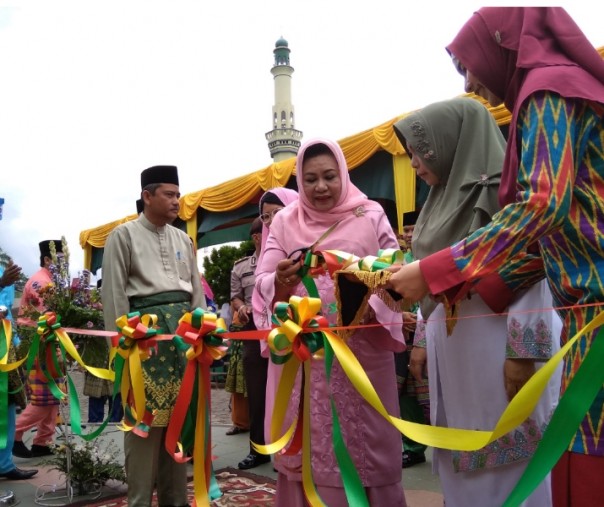 Ketua Dekranasda Provinsi Riau Wan Rosmiati memotong pita tanda dibukanya bazar MTQ di halaman Masjid An-Nur, Rabu (12/12/2018). Foto: Surya/Riau1.