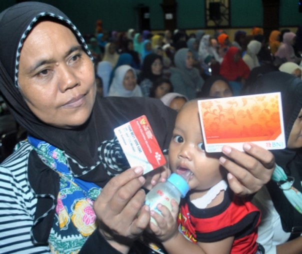 Warga menunjukkan Kartu Keluarga Sejahtera saat Penyaluran Bantuan Sosial Program Keluarga Harapan (PKH) dan Bantuan Sosial Pangan Beras Sejahtera (Bansos Rastra). Foto: Antara.