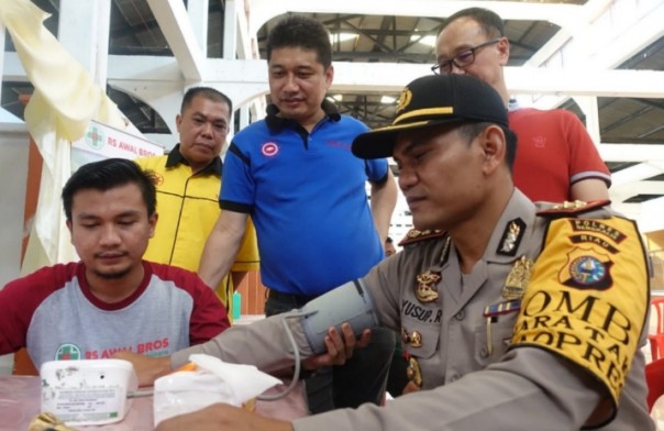 Ketua IKPTB, Toni (kaos biru) mendampingi Kapolres Bengkalis, AKBP Yusup Rahmanto saat cek kesehatan di program baksos di Bengkalis