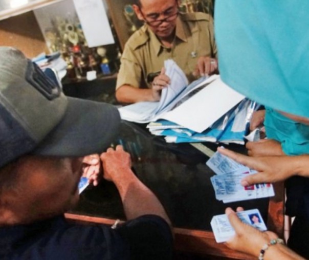 Petugas Kelurahan melayani warga saat pengambilan KTP-el. Foto: Antara.
