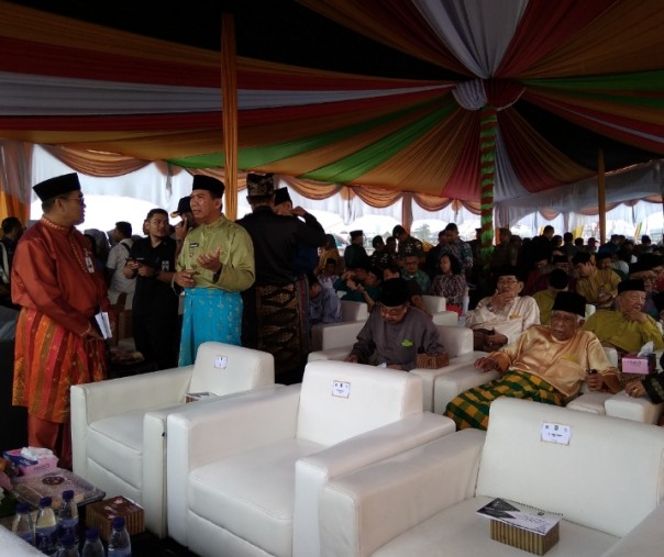 Wali Kota Pekanbaru Firdaus bersama pejabat Pemprov Riau berbincang sembari menunggu peresmian Jembatan Siak IV yang diguyur hujan deras, Kamis (14/2/2019). Foto: Surya/Riau1.