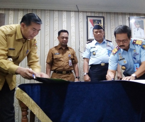 Wali Kota Pekanbaru Firdaus bersama Kepala Kanwil Kemenkumham Riau menandatangani kerja sama pembukaan layanan keimigrasian di Mal Pelayanan Publik Pekambaru, Senin (18/2/2019). Foto: Surya/Riau1.