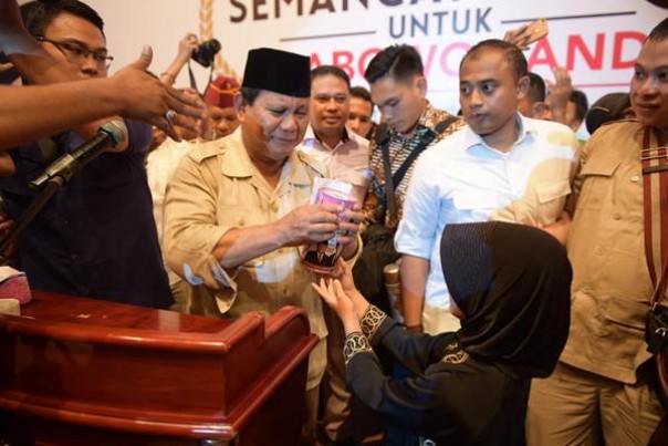 Seorang siswi SD bernama Gendis menyerahkan hasil tabungannya pada Prabowo Subianto di Medan, Sabtu. 