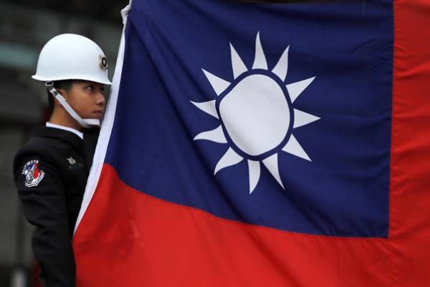Seorang tentara memegang bendera Taiwan. 