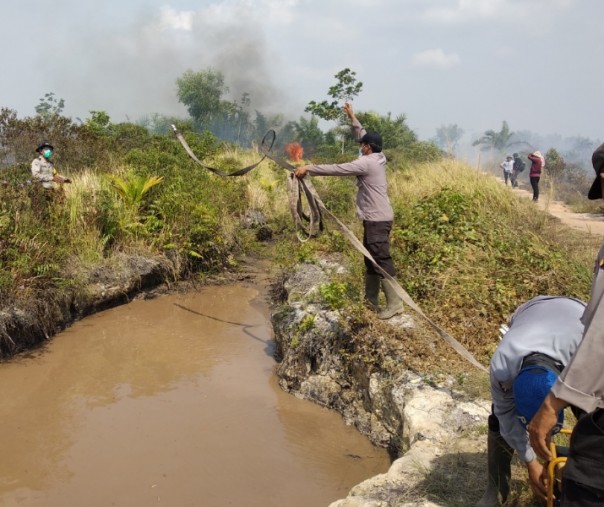 Aparat kepolisian di Dumai Timur melakukan pemadaman di lahan terbakar, Kamis siang (Foto: Riau1)