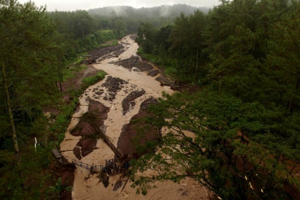 Ilustrasi sebuah sungai yang membelah hutan dan longsor terlihat dari atas.