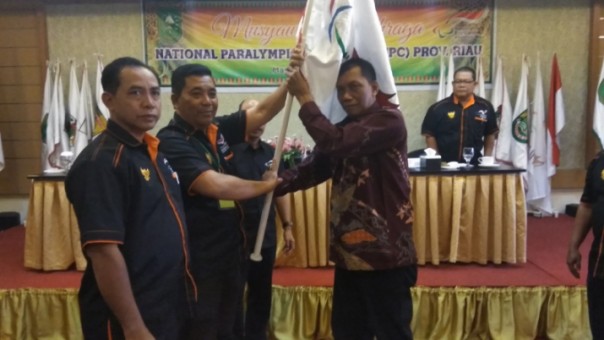 Ketua NPC Riau terpilih, Jaya Kusuma (paling kanan) menerima bendera pataka setelah aklamasi dalam Musorprov NPC Riau di Hotel Drego Pekanbaru (foto: barkah/riau1.com)