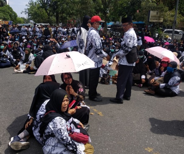 Para guru tampak duduk di jalan sambil membacakan Surah Yasin.