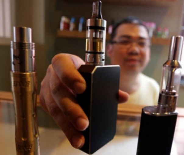 Seorang pedagang rokok elektronik (e-cigarette) memperlihatkan tiga buah rokok elektrik. Foto: Antara.