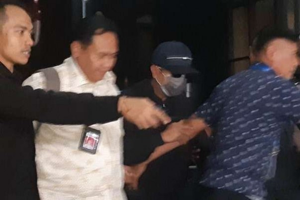 Tersangka Romahurmuziy memakai topi dan masker saat tiba di Gedung KPK Jakarta, Jumat malam. 