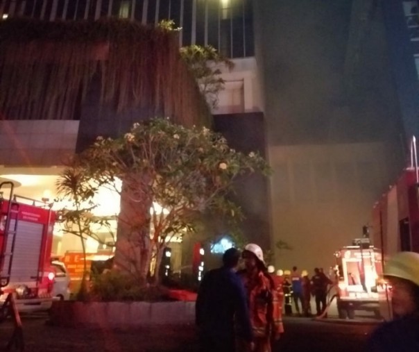 Tampak asap ke luar dari basement hotel, petugas Damkar bergerak cepat memadamkan api agar tidak menjalar.