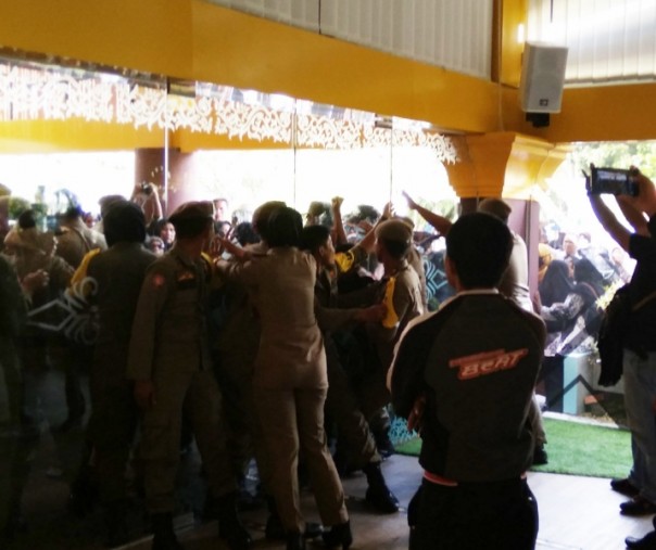 Aksi saling dorong antara guru yang berdemo dengan Satpol PP di pintu masuk MPP Pekanbaru, Senin (25/3/2019). Foto: Surya/Riau1.