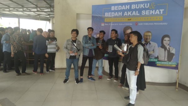 Sejumlah peserta berfoto di area photo booth sambil menanti kedatangan Rocky Gerung di GOR Tribuana Pekanbaru (foto: barkah/riau1.com)