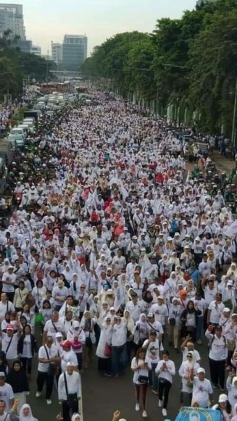 Rombongan massa pendukung Prabowo-Sandi berjalan menuju GBK, Sabtu sore. 