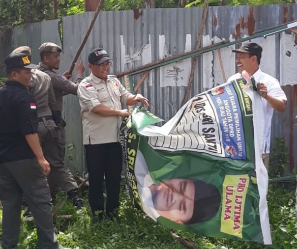 Ketua Bawaslu Riau Rusidi Rusdan saat mencopot APK salah satu caleg di masa tenang Pemilu, Minggu (14/4/2019). Foto: Bawaslu Riau.