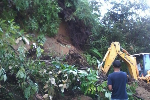 Petugas memberikan badan jalan tertimbun longsor di Malalak, Kabupaten Agam, Sumatera Barat, Senin.