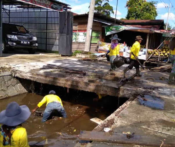 Pekerja dari Dinas PUPR Pekanbaru saat membersihkan drainase di Jalan Arifin Ahmad, Rabu (24/4/2019). Foto: Surya/Riau1.