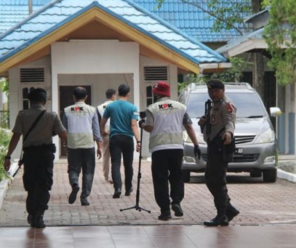 Sejumlah penyidik Komisi Pemberantasan Korupsi (KPK) dan aparat kepolisian berjalan menuju tempat parkir mobil rumah dinas Wali Kota Dumai saat akan dilakukan penggeledahan di kota Dumai, Riau, Jumat (26/4/2019). Foto: Antara.