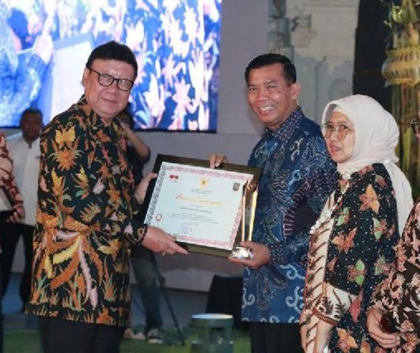 Mendagri Tjahjo Kumolo menyerahkan Piagam Satya Lencana Karya Bhakti Praja Nugraha kepada Wali Kota Pekanbaru Firdaus dalam HUT Otonomi Daerah ke-23 di Kabupaten Banyuwangi, Provinsi Jawa Timur pada 25 April 2019. Foto: Istimewa.